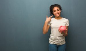 woman with piggy bank pointing to her smile 