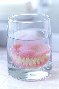 Dentures in Orange soaking in glass