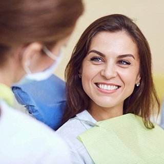 a patient smiling after receiving her dental bridges