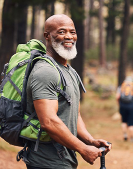 an older man smiling during a hiking trip