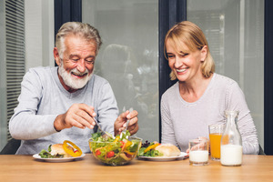 Senior couple smiling and eating a salad