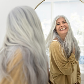 Dentures patient in Orange smiling in the mirror