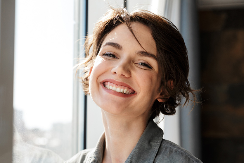 Woman smiling with window in background