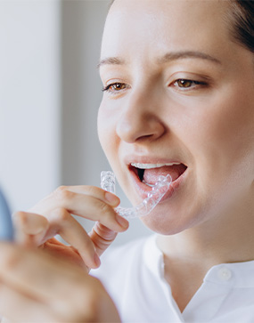 Woman putting on clear aligner