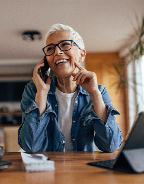 Woman with glasses smiling while talking on phone