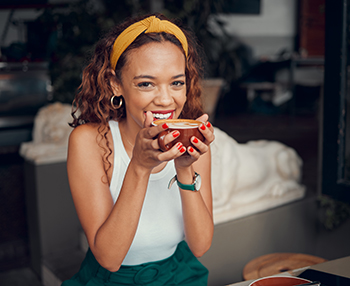 Woman smiling while enjoying cup of coffee