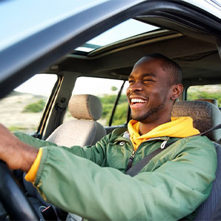 Man smiles while driving.