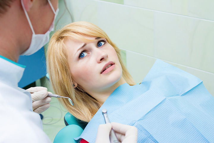 Woman afraid in the dental chair.